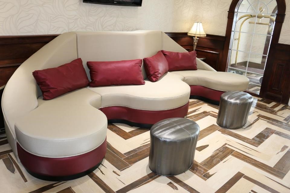 North-Bergen-NJ-interior-of-corporate-lounge-abstract-unique-shaped-cream-and-red-leather-couch-with-red-leather-pillows-and-leather-foot-rests