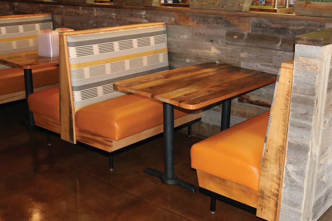 Raleigh-NC-detailed-view-of-orange-and-gray-patterned-restaurant-booths-facing-wood-table
